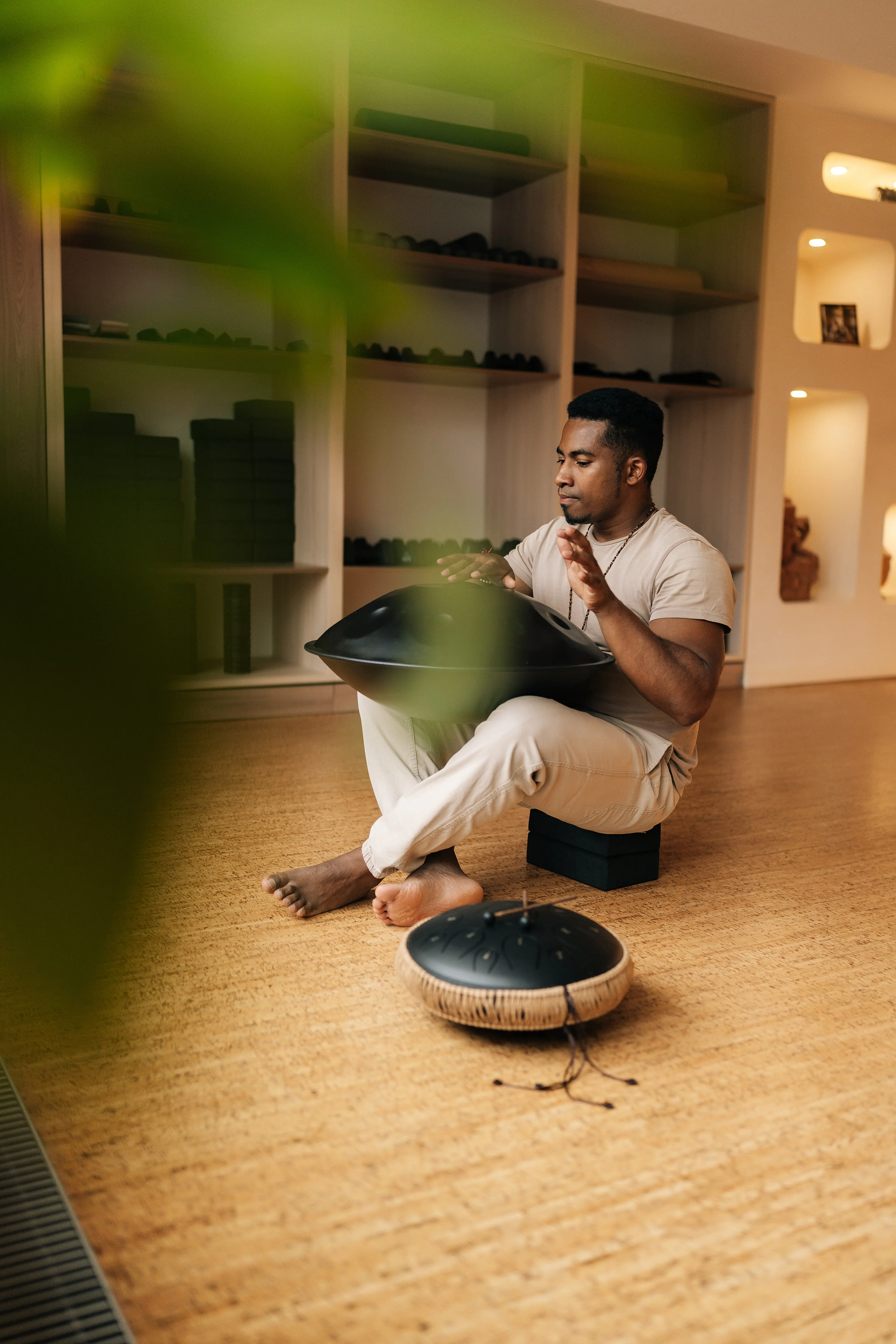 Hochformatiges Porträt eines gelassenen afrikanischen Mannes in Trance, der auf einer Tank Drum ethnische, einheimische Musik spielt, von